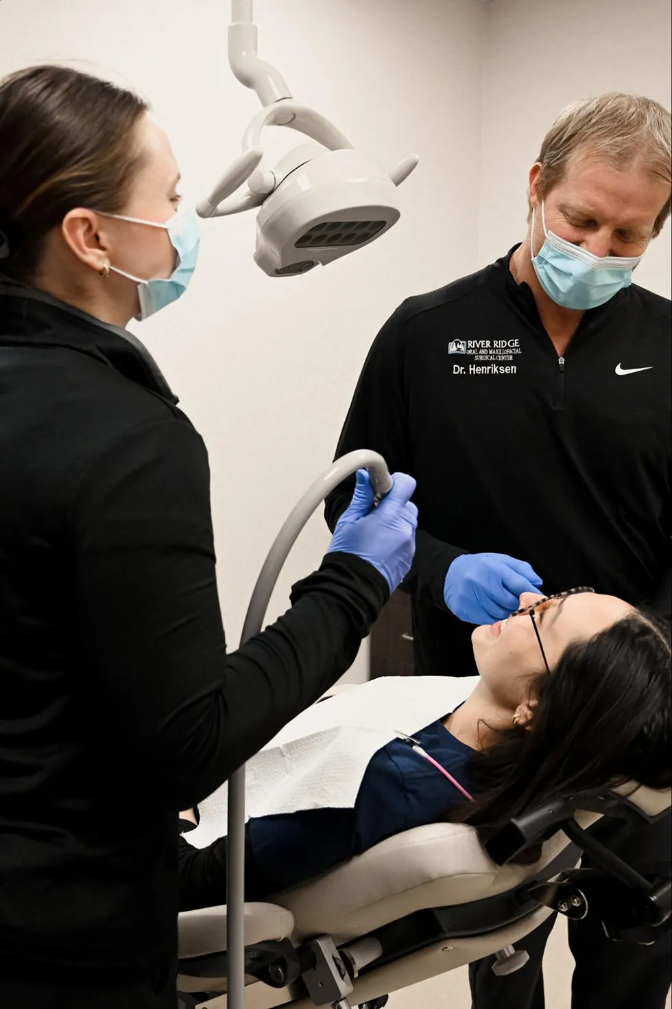 A clinical team at River Ridge Oral & Maxillofacial Surgical Center providing specialized care under a surgical light during a wisdom teeth removal surgery or dental implant procedure in Sioux Falls