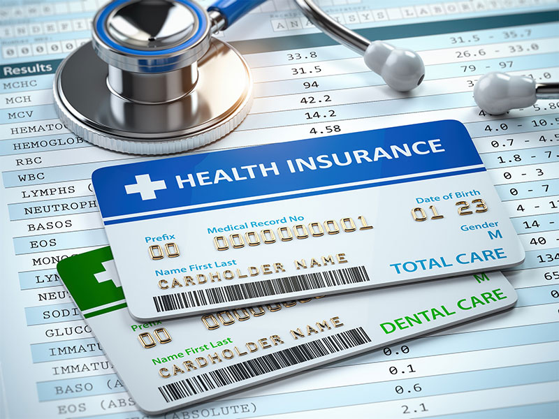 A stethoscope resting on medical insurance and dental care cards, highlighting the insurance and financing options available to help patients manage the cost of dental implants or wisdom teeth removal at River Ridge Oral & Maxillofacial Surgical Center.