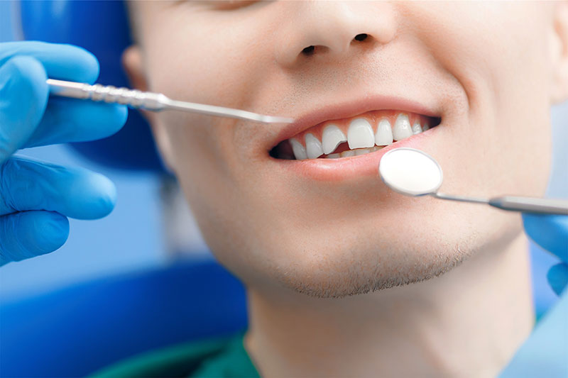 A patient at River Ridge Oral & Maxillofacial Surgical Center receiving a precise post-operative exam to ensure proper healing after a dental implant procedure or surgical tooth extraction in Sioux Falls.